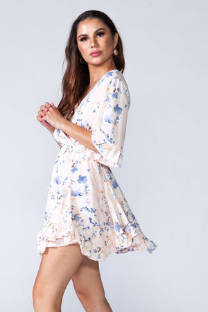 Dancing Queen Dress - Whitish floral ruffled summer mini dress with V-neck and short sleeves. Model posing for side view