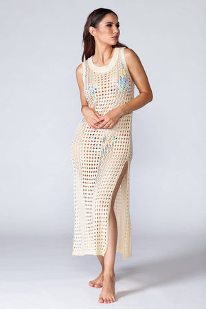 Hera Beach Dress Beige - Hollowed-out kaftan in beige color, sleeveless and stretchable. Model in natural pose