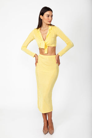 Miss Sunrise Set - Model wearing set of top and skirt in yellow color with long sleeves and crop top ina natural pose