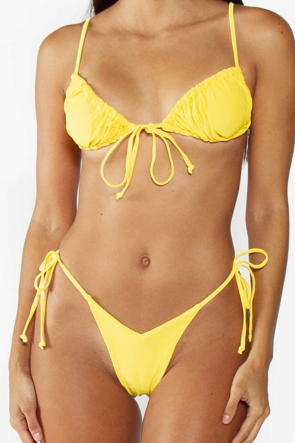 Model wears trendy two-piece swimwear in yellow color, zoom on self tie detail