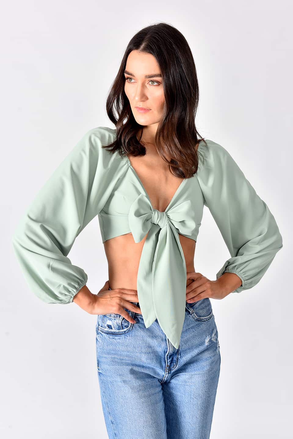Model in a natural pose while wearing trendy crop top in green color