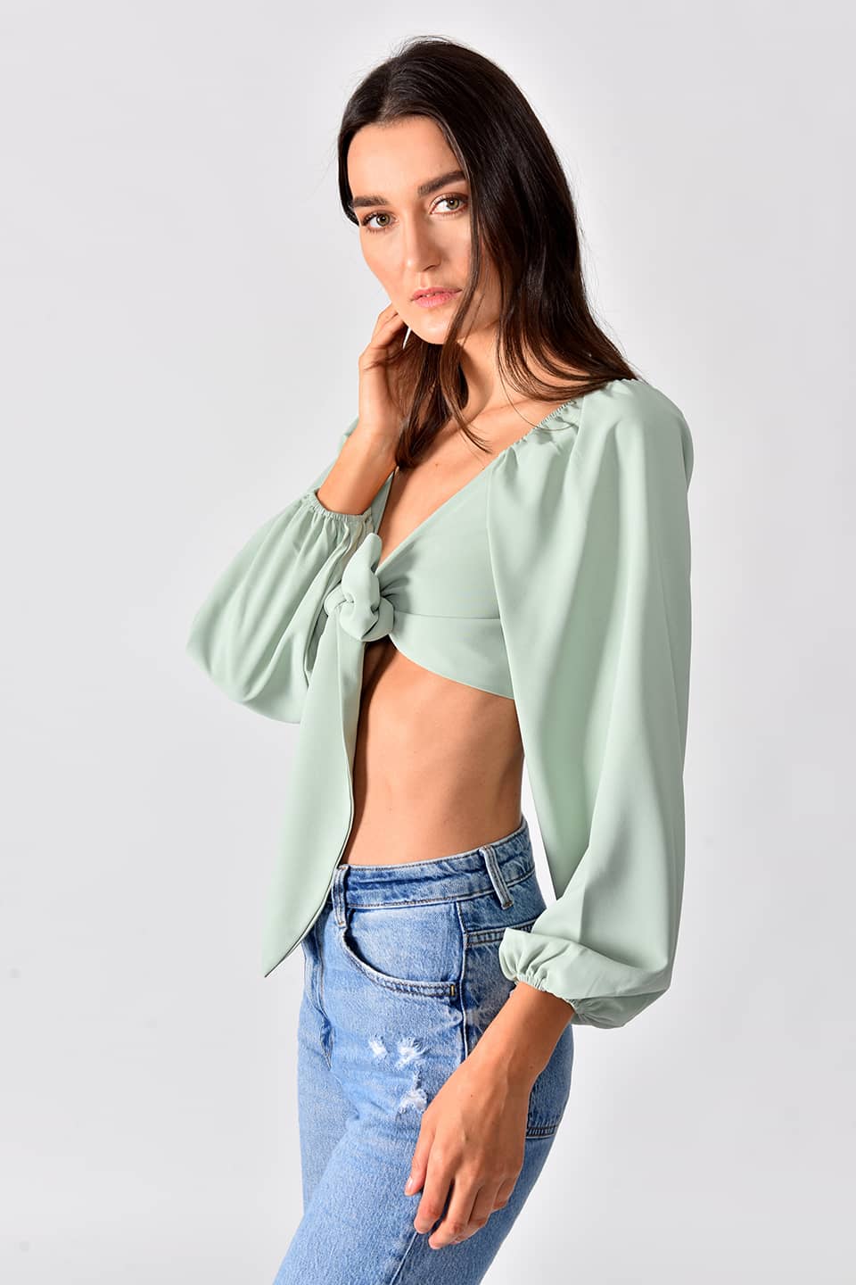 Model in pose from right side while wearing trendy crop top in green color