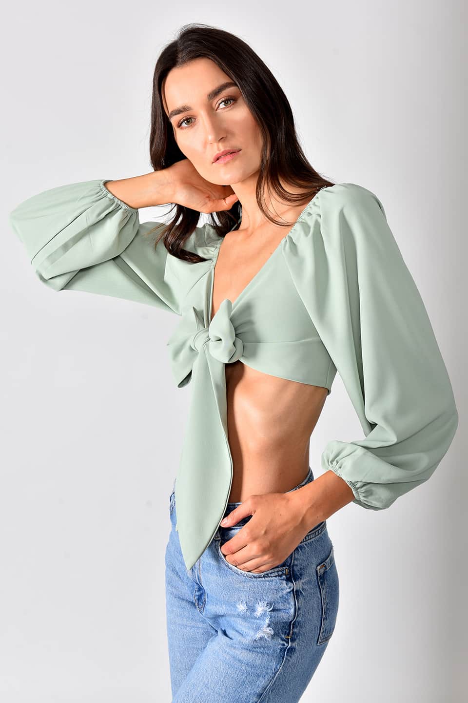 Model in pose from a side while wearing trendy crop top in green color