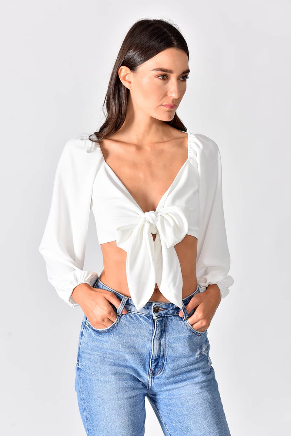 Model in a natural pose, while wearing trendy crop top in white color