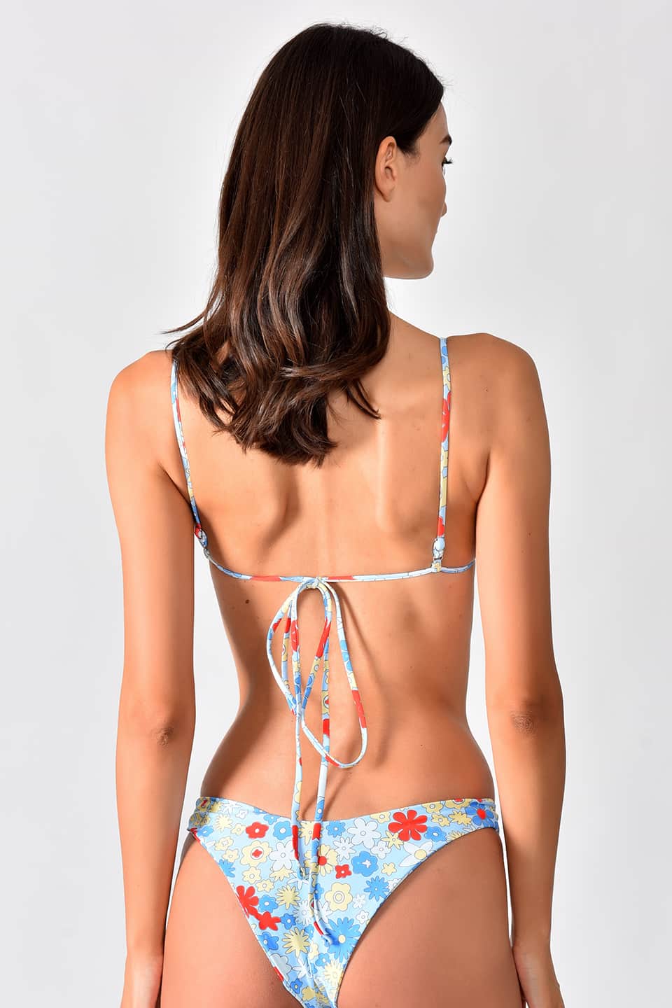 Model in pose from behind is showing colorful bikini with flower pattern, flat top and high waist bottom.