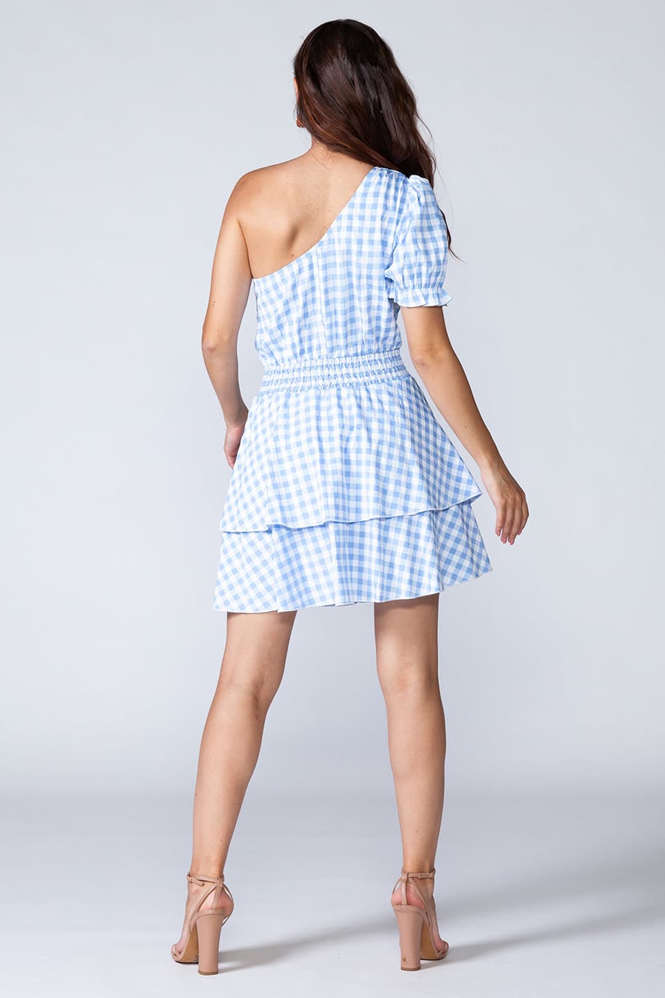 Blue flamenco, one shoulder mini dress in light blue and white, model posing from behind