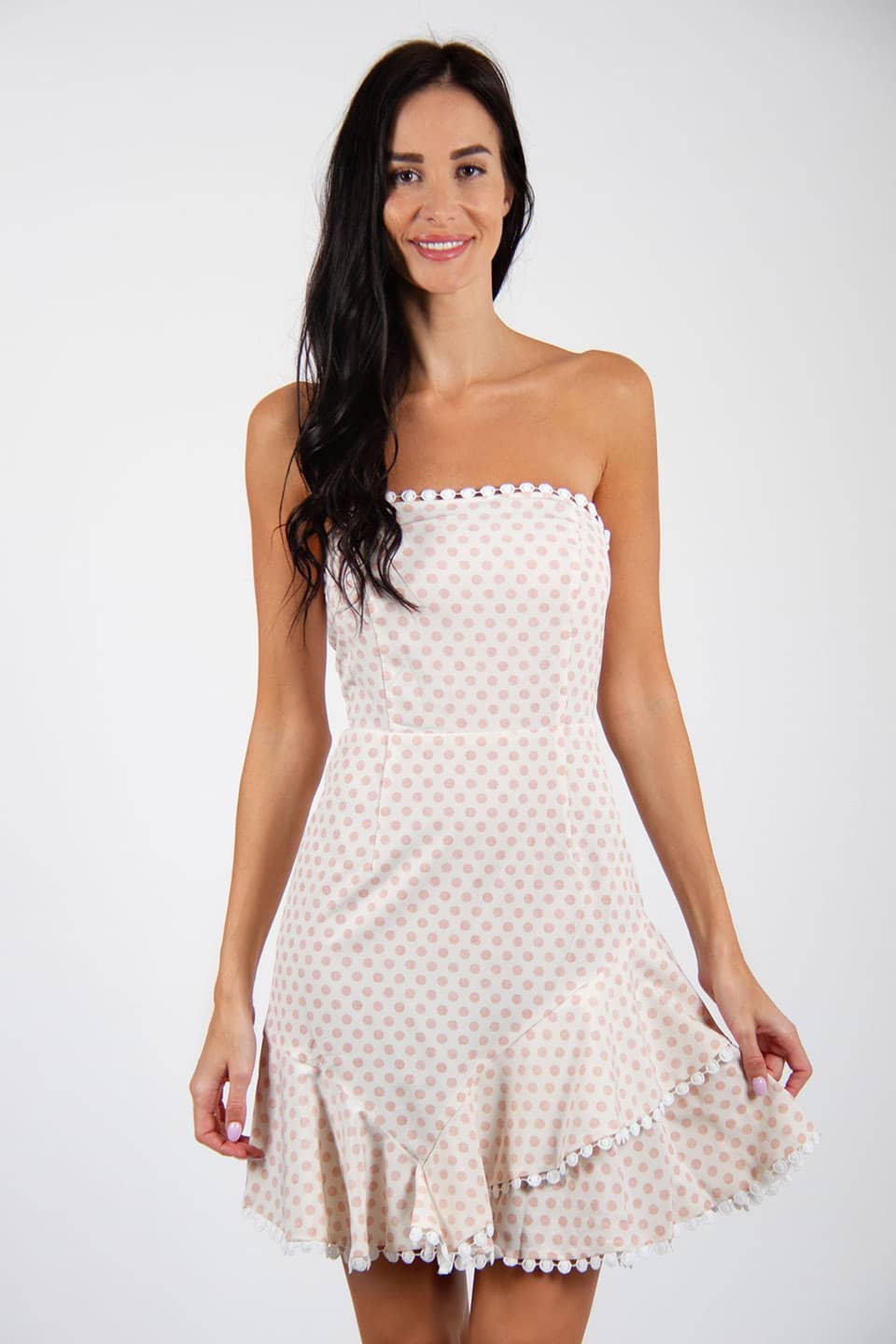 Dot printed, off-shoulder mini dress in white color. Model front posing