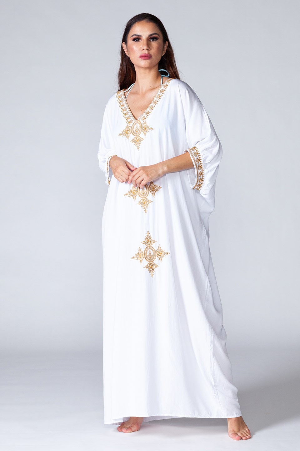 Mid sleeve white kaftan with golden details, model posing for front view