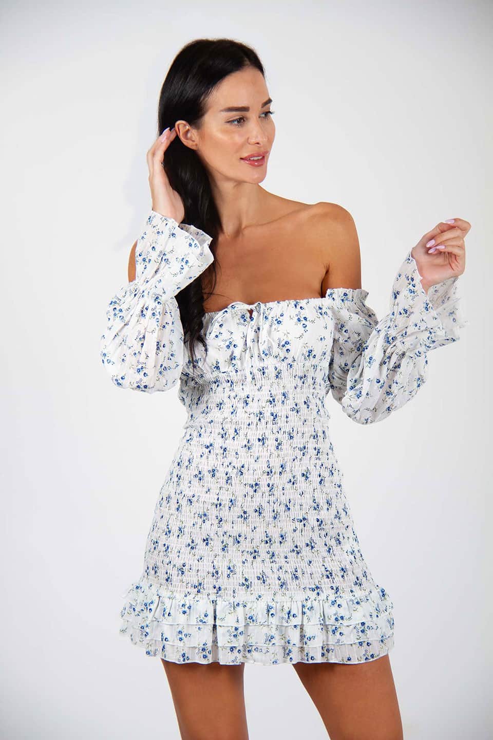 Off-shoulder floral print mini dress, trendy and sleeveless. Model posing natural