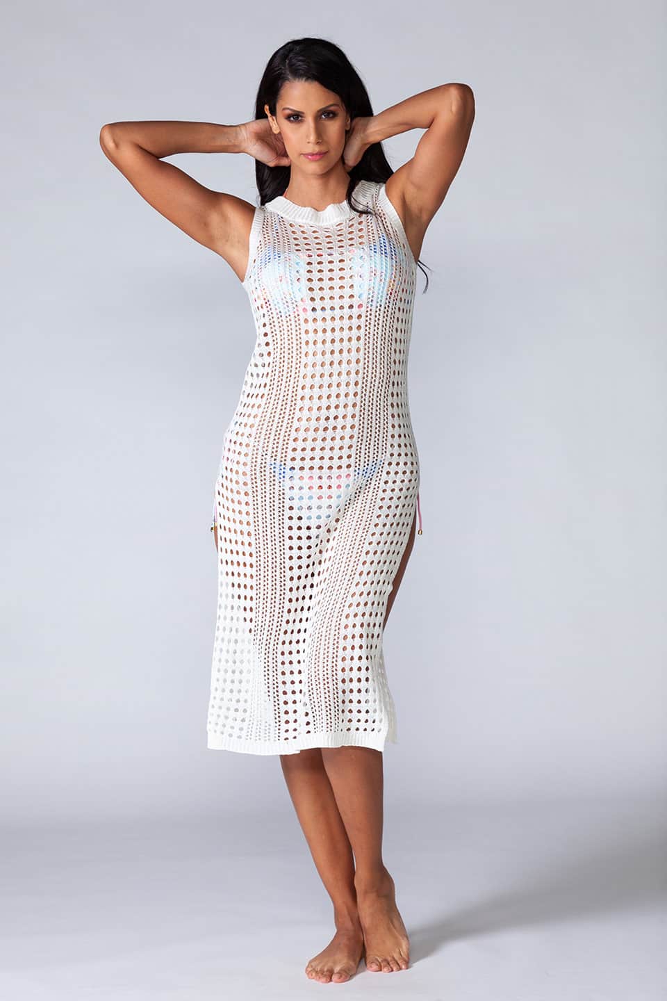 Hollowed-out kaftan in white color, sleeveless and stretchable. Model posing natural