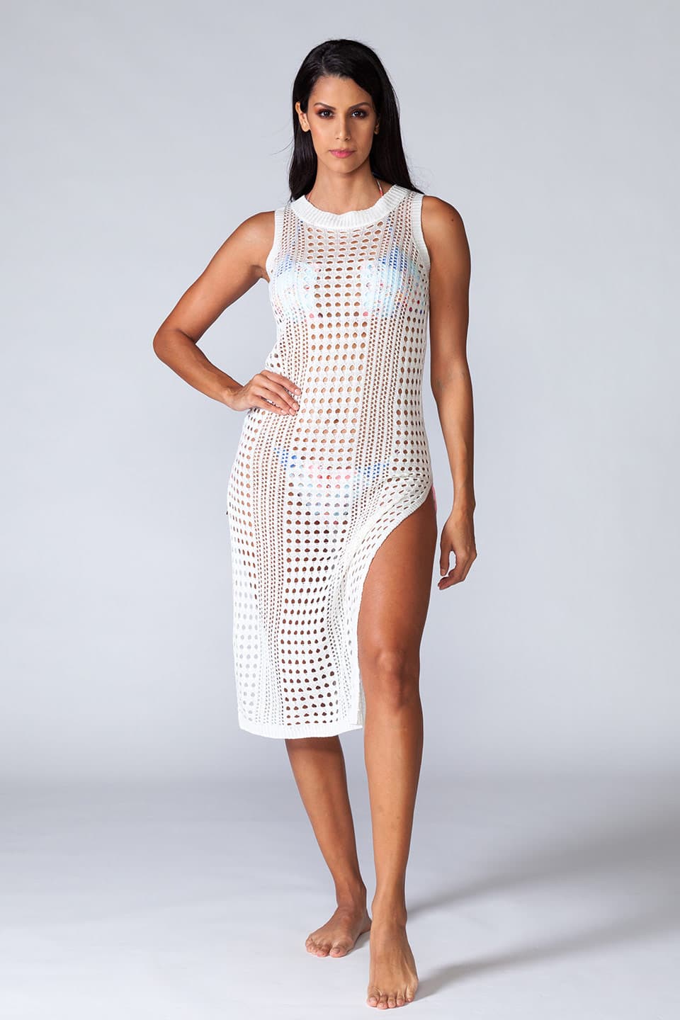 Hollowed-out kaftan in white color, sleeveless and stretchable. Model posing in frontal view