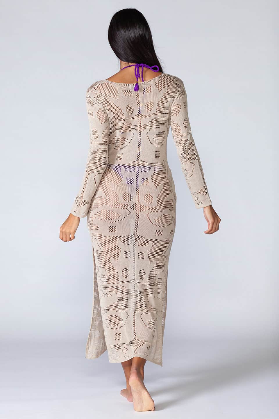 Knitted hollowed-out kaftan with long sleeves and ties in the front. Model posing from behind