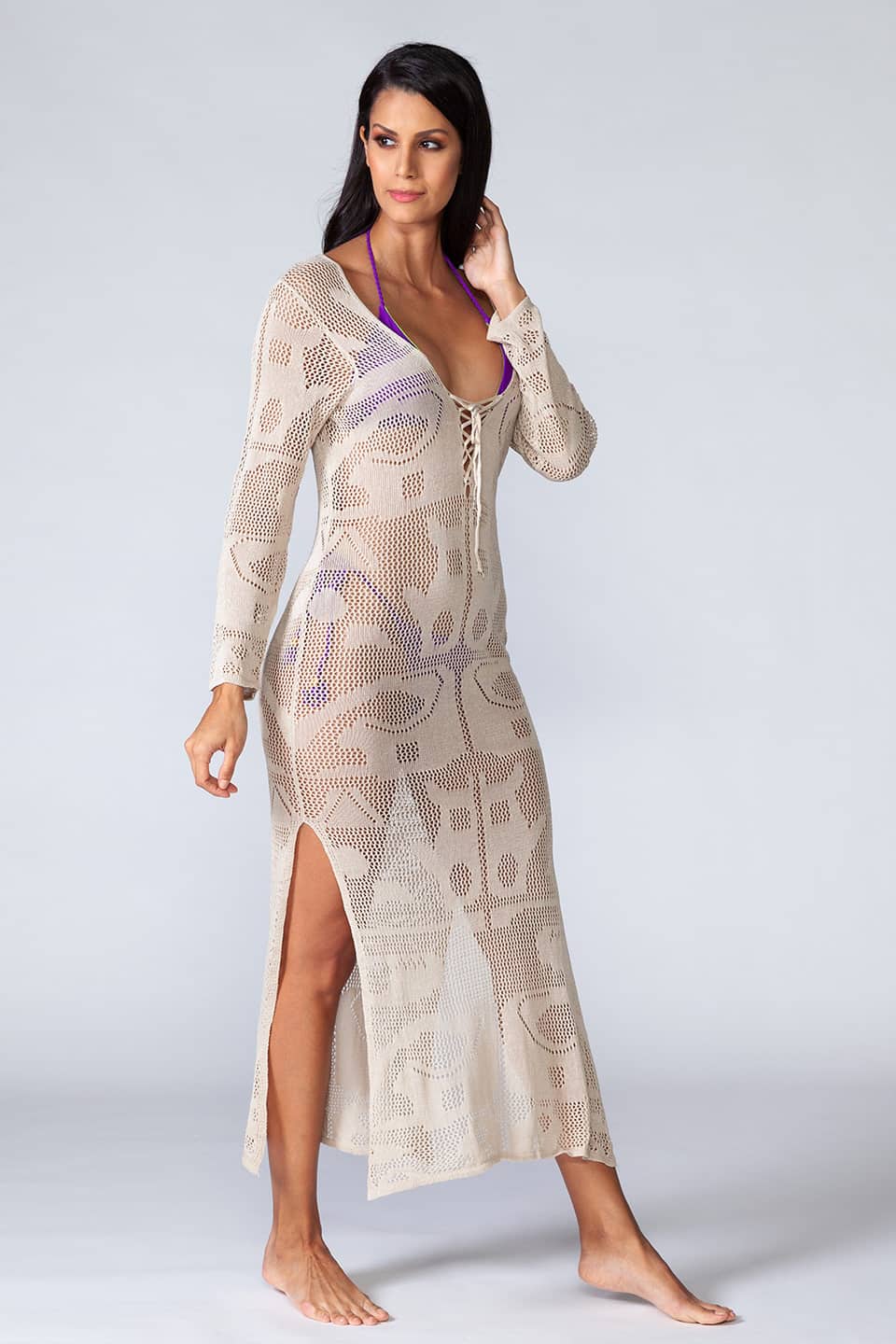 Knitted hollowed-out kaftan with long sleeves and ties in the front. Model posing on side view