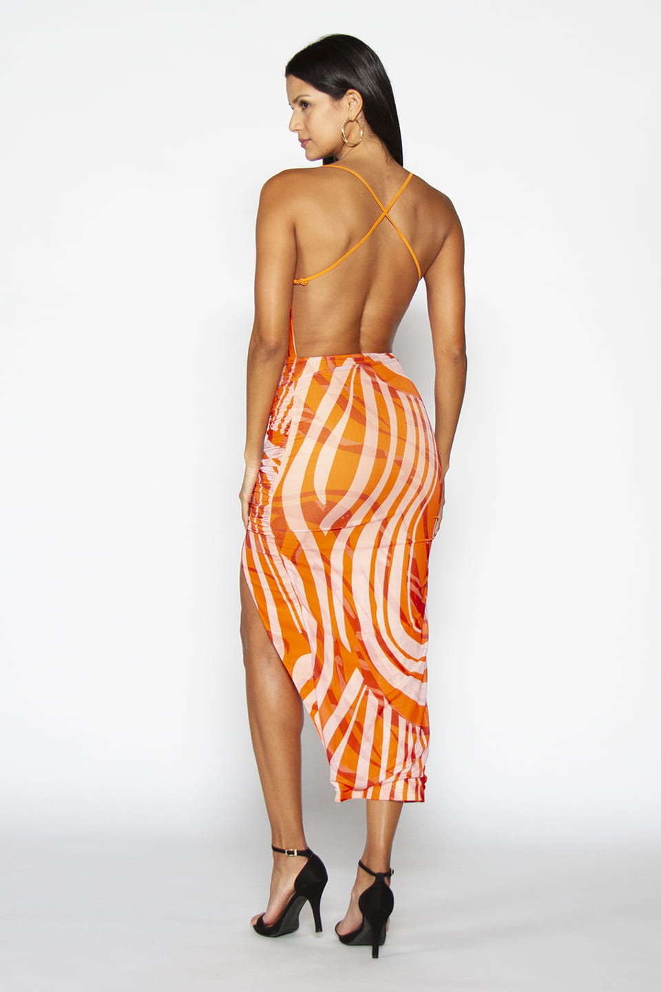 Backless over the knee Orange dress with two adjustable criss-cross straps on the back. Model posing from behind