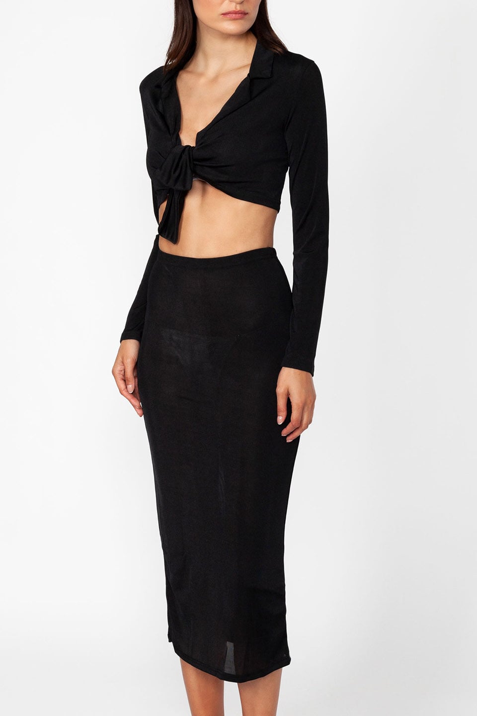 Model wearing set of top and skirt in black color with long sleeves and crop top, material details zoom