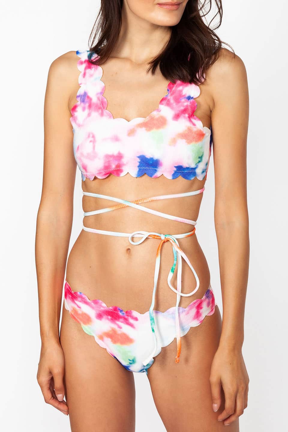 Model wears multicolor two-piece swimwear with self-tie straps around the waist, texture and material details