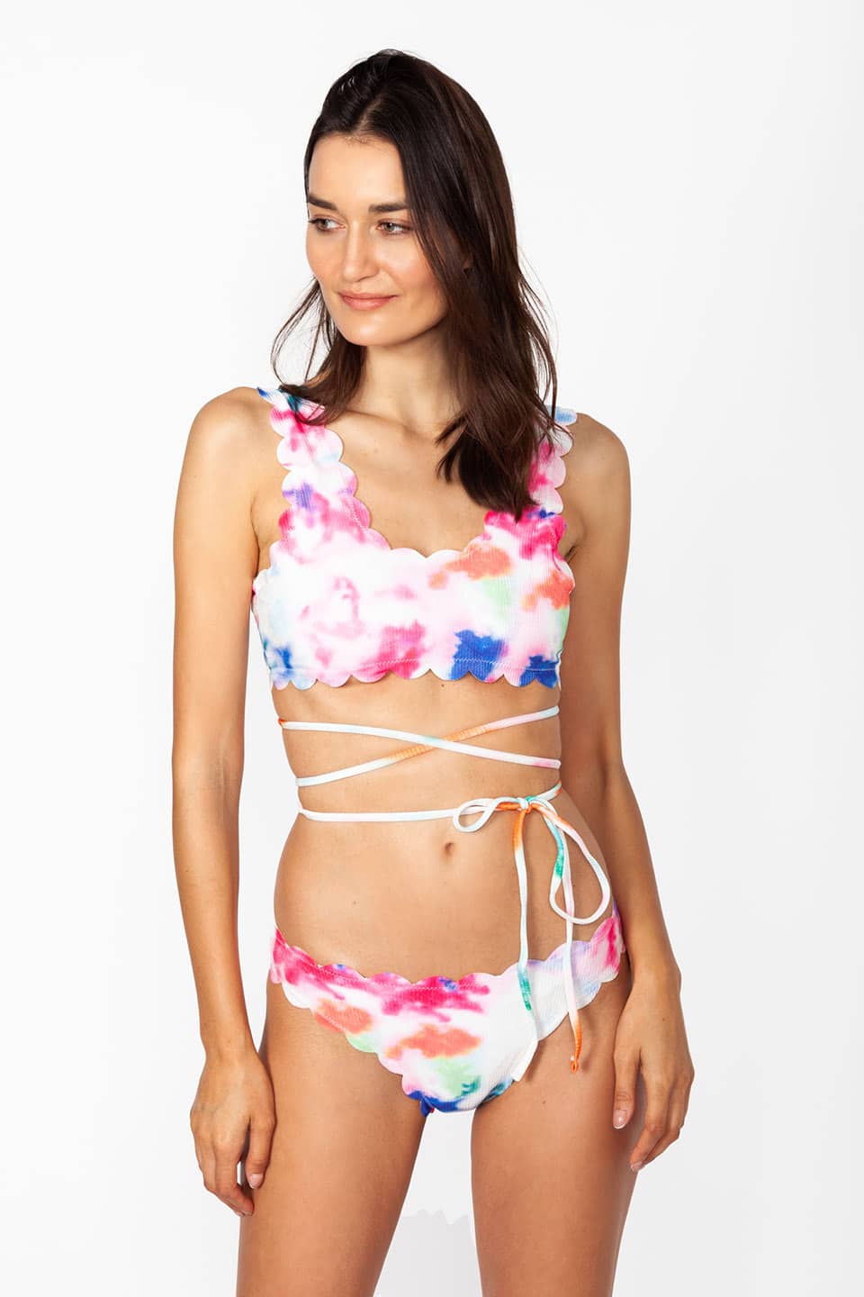 Model wears multicolor two-piece swimwear with self-tie straps around the waist, looking aside
