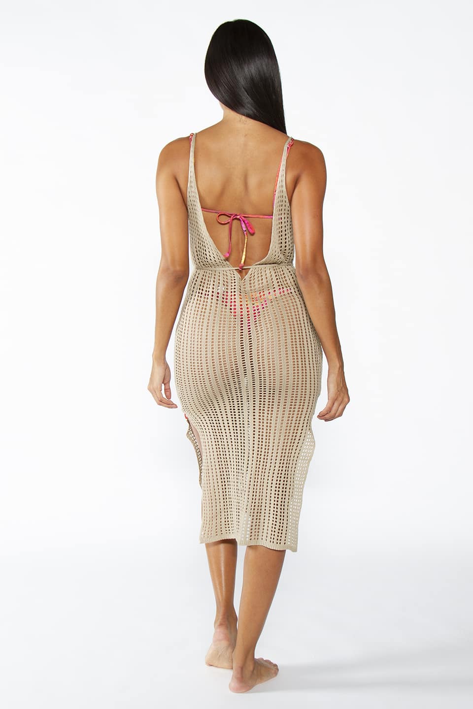 Kaftan beach dress in beige color with open back and belt around the waist. Model is posing from behind