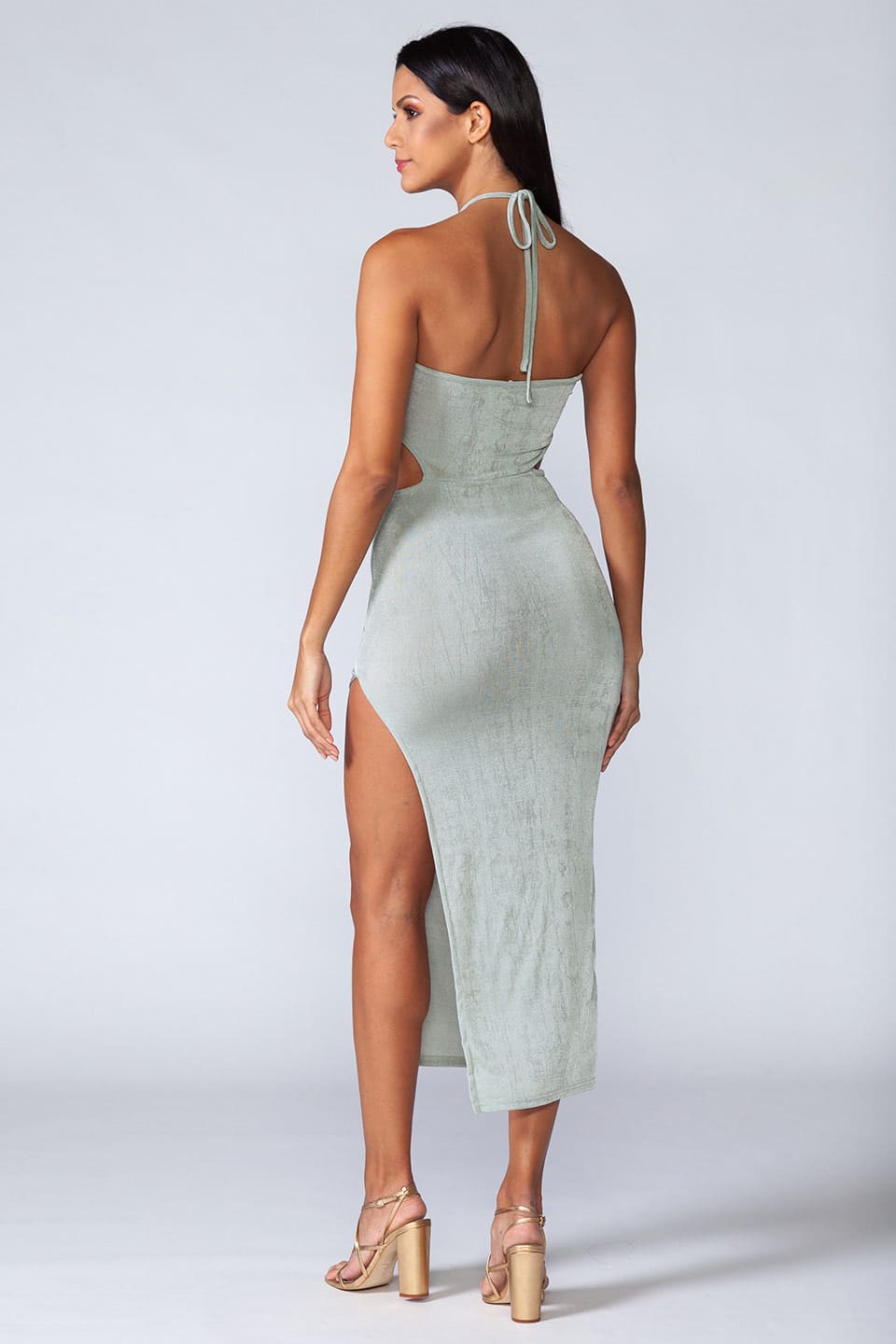 Model wears trendy turquoise midi dress with high slit on the side, posing from behind