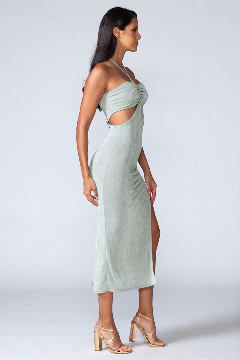 Model wears trendy turquoise midi dress with high slit on the side, posing on right side