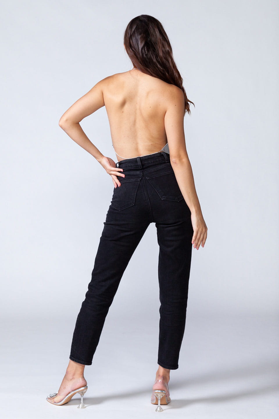 Model wears metal crop top in silver color, full body from behind