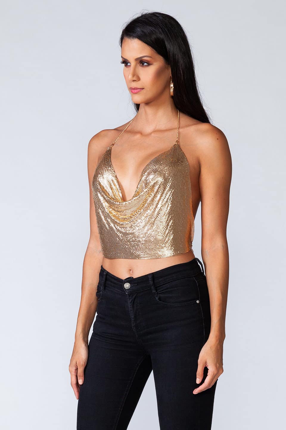 Model wears metal crop top in gold color, in natural pose