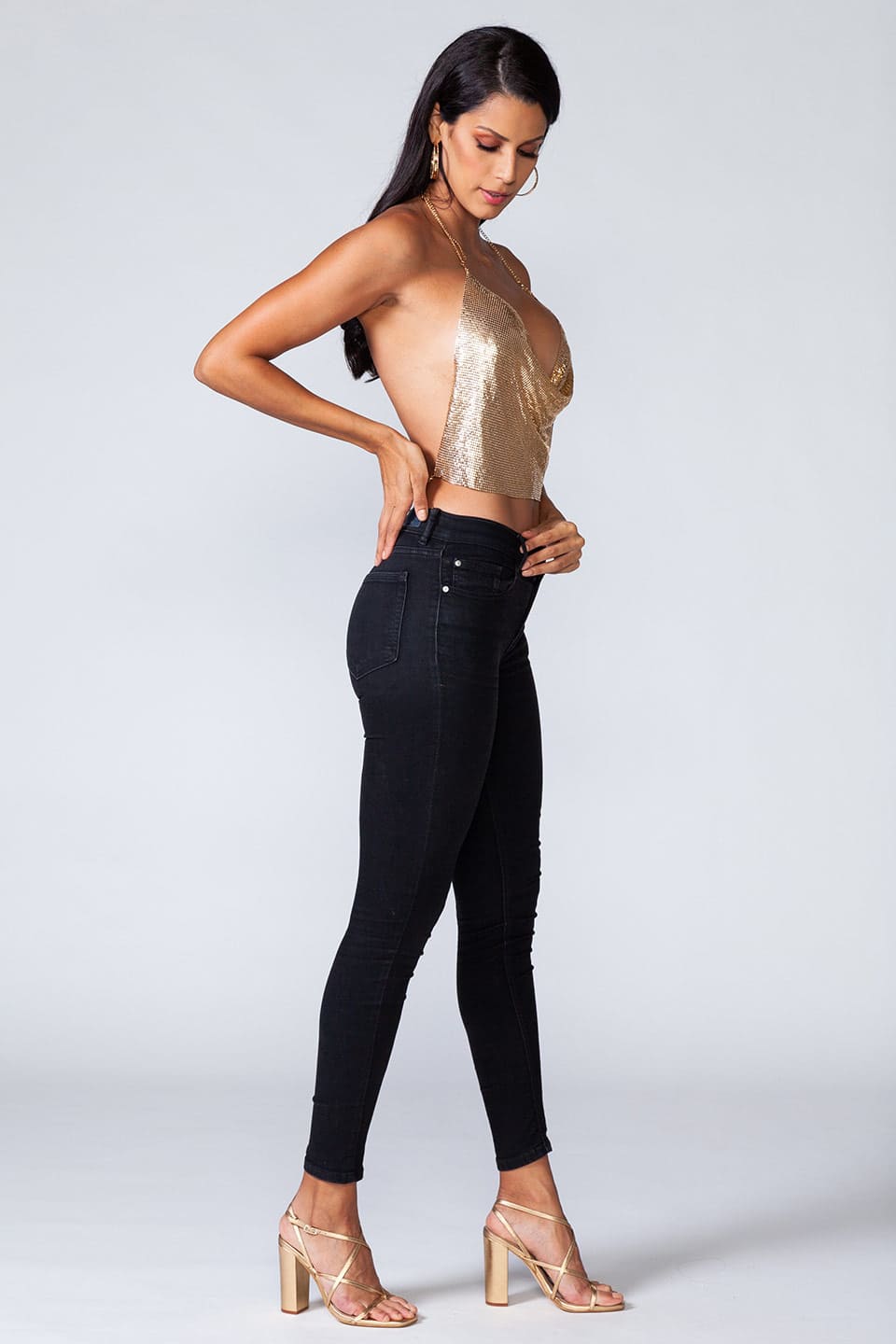 Model wears metal crop top in gold color, full body view