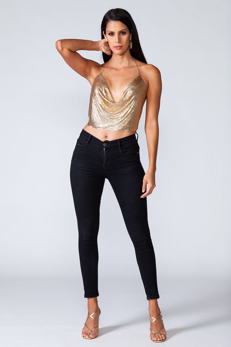 Model wears metal crop top in gold color, in full body natural pose