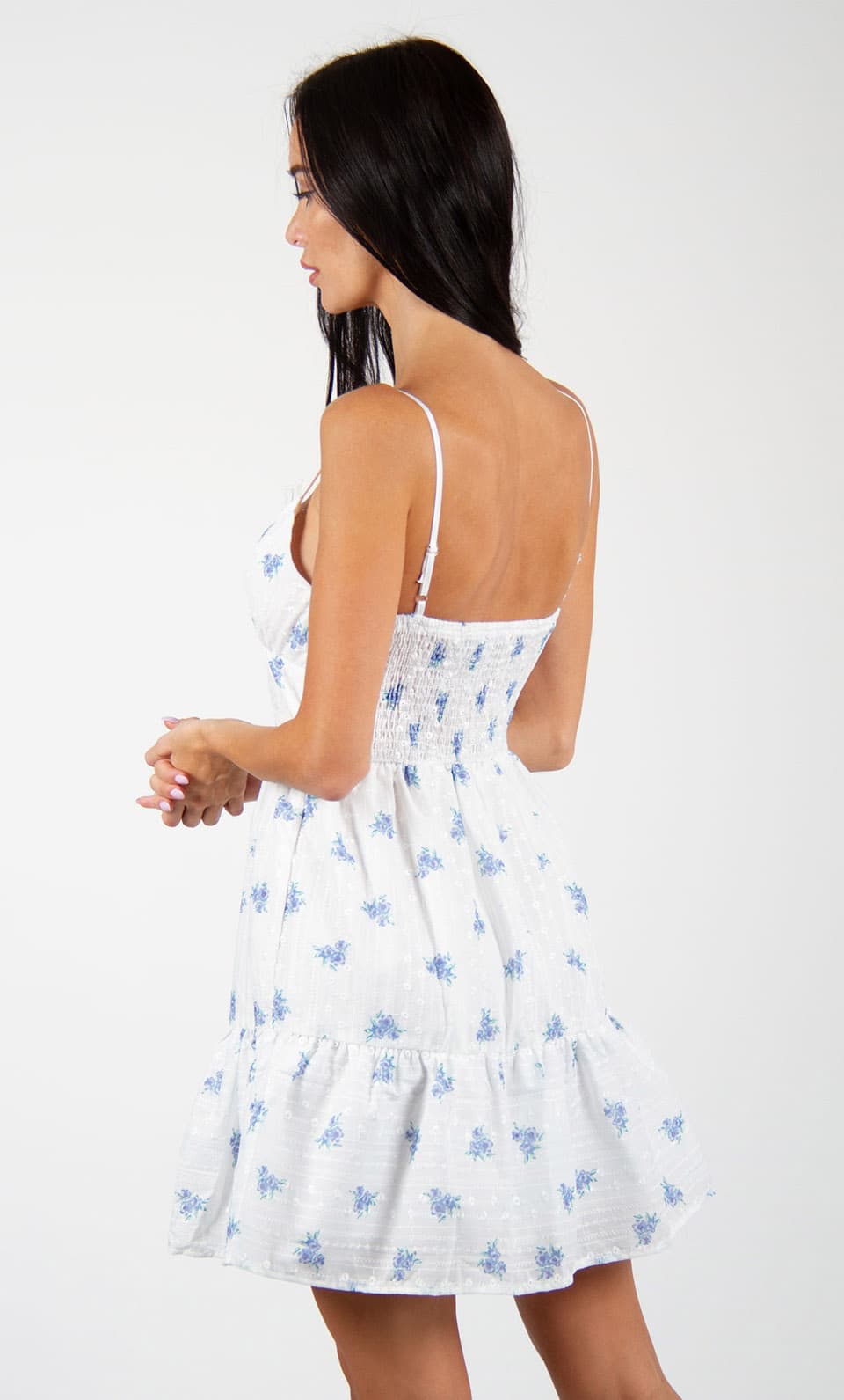 Model wearing mini swing dress with embroidery texture and flower print, posing from behind