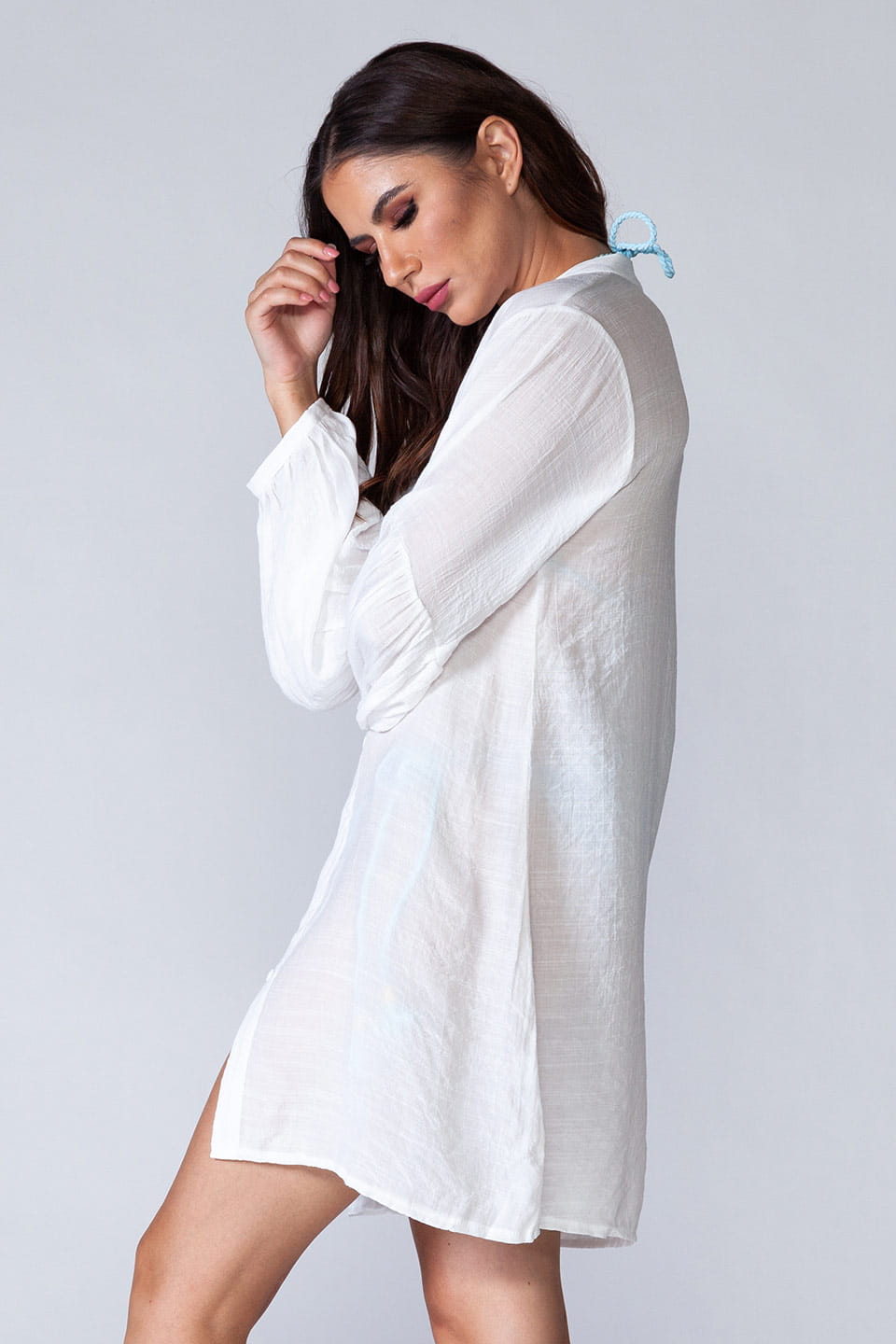 Model wearing long sleeved beach shirt kaftan style, in a natural pose