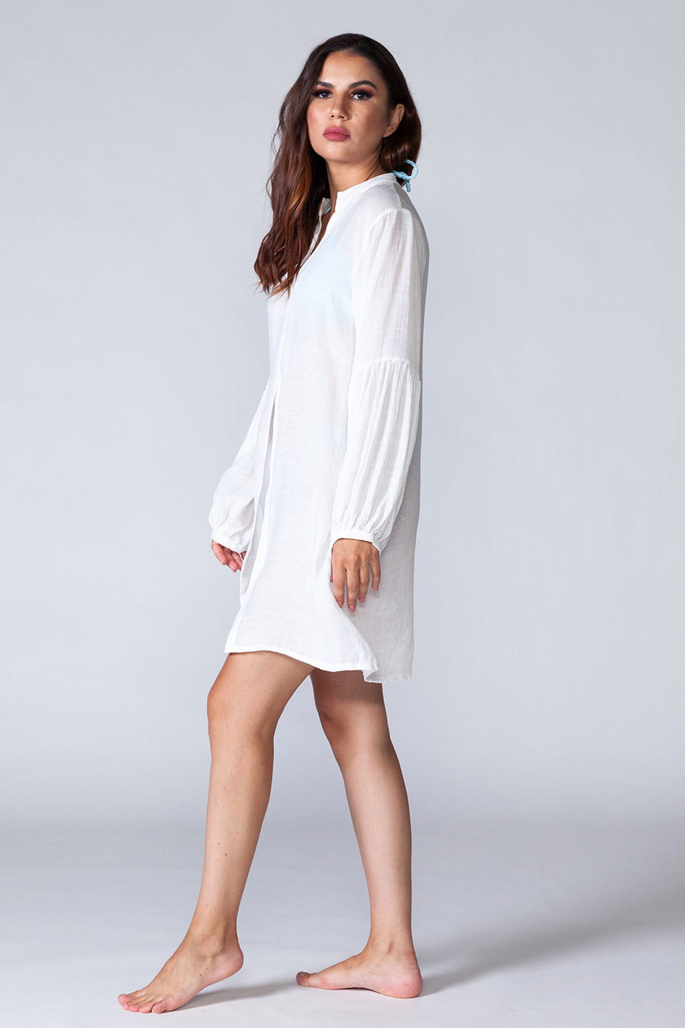 Model wearing long sleeved beach shirt kaftan style, posing on a side full body
